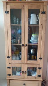 a wooden cabinet with glass doors with dishes in it at Estalagem Santa Fé in Cambará