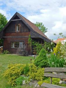 a wooden house with a bench in front of it at Domki - Mazurski Zaścianek in Kruklanki