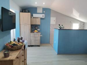 una cocina con paredes azules y un bol de fruta en una barra en Blue View Apartments, en Trogir