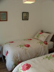 two beds in a room with flowers on them at Pen Llyn Quarryman's Cottage in Trefor