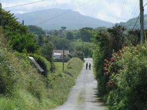 two people walking down a dirt road at Pen Llyn Quarryman's Cottage in Trefor