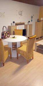 una mesa y sillas en una habitación con cocina en Monteurunterkunft Haus Barbara Pirmasens, en Pirmasens