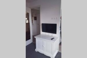 a living room with a tv on a white stand at Duplex 1 station tramway aéroport Paris-Orly in Athis-Mons