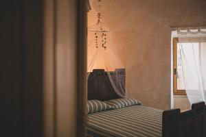 a bedroom with a bed with a canopy and a window at NICE APARTMENT in Porto Santo Stefano