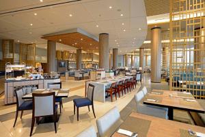 a restaurant with tables and chairs in a building at Discovery Ancol in Jakarta