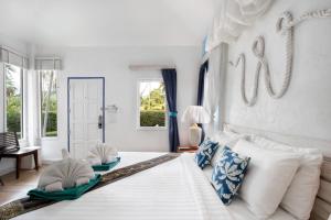 a bedroom with a large white bed with pillows at The White Knot Koh Chang in Ko Chang