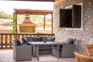 een patio met een tafel en stoelen en een grill bij Villa in the Woods in Kolimbia