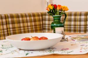 un tazón de manzanas en una mesa con un jarrón de flores en Salzburg-Chalet, en Grossgmain