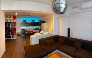 uma sala de estar com um sofá e uma cozinha em GIS North House em Bucareste