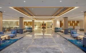 a lobby of a hotel with blue chairs and tables at Discovery Ancol in Jakarta +37 photos