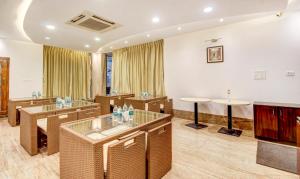 a meeting room with tables and chairs and a tv at Treebo Trend The Sai Leela Suites R T Nagar in Bangalore