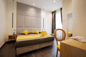 a bedroom with a large bed with yellow pillows at Hotel Garden in Levanto