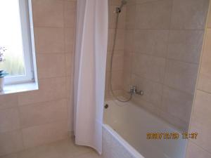 バラトンフレドにあるBoglárka Apartmanházのバスルーム(バスタブ、シャワー、シャワーカーテン付)が備わります。