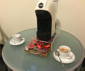 - une cafetière sur une table avec deux tasses de café dans l'établissement Hotel Garden, à Levanto