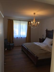 a bedroom with a bed and a chandelier at Ferienwohnung Neureiter in Golling an der Salzach