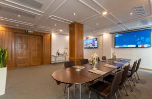 Sala de conferencias con mesa, sillas y pantalla en Kydon The Heart City Hotel, en La Canea