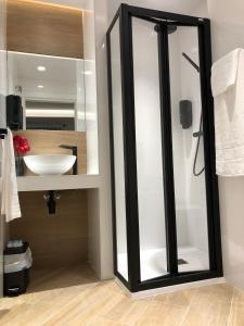 a glass shower in a bathroom with a sink at Hostal León in Torreorgaz