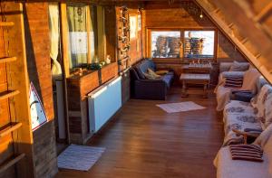 a living room with couches and a table in a cabin at Birdshouse Parang in Petroşani