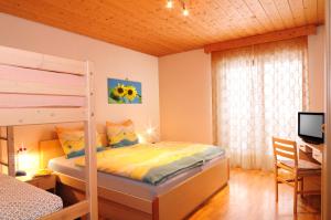 a bedroom with a bunk bed and a desk at Rastlhof in Meltina