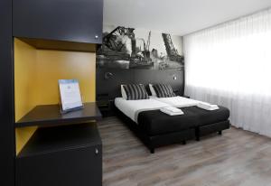 1 dormitorio con cama y escritorio. en City hotel Terneuzen en Terneuzen