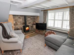 a living room with a couch and a fireplace at Cotstone Cottage in Chipping Campden