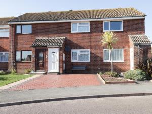 a red brick house with a white door at Jay Cottage in Weymouth