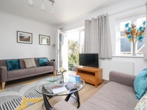 sala de estar con sofá y TV en Castle Cove View, en Weymouth