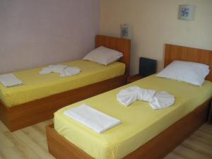 two beds in a hotel room with towels on them at Brani Family Hotel in Ruse