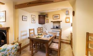 a dining room with a table and chairs and a fireplace at Croft End Cottage in Sawrey