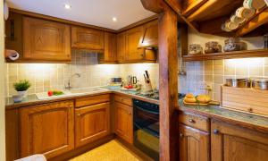 a kitchen with wooden cabinets and a sink at Croft End Cottage in Sawrey +7 photos