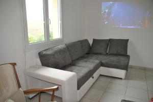 un sofá en una sala de estar con ventana en Gite De La Suche, en Lamastre