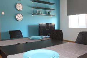 mesa de comedor con sillas y relojes en la pared en Apartamento Morales - 2 habitaciones, espacioso y tranquilo junto a Hospital, en Murcia