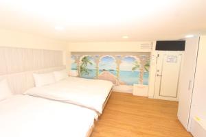 a bedroom with a bed and a painting of the ocean at Sea Keelung in Keelung