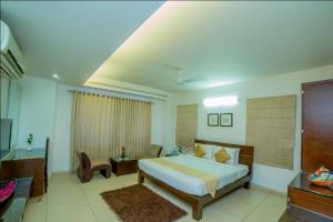 a hotel room with a bed and a desk and a room at Hill View Hitech City in Hyderabad