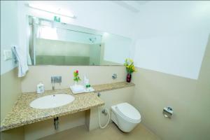 a bathroom with a sink and a toilet and a mirror at Hill View Hitech City in Hyderabad