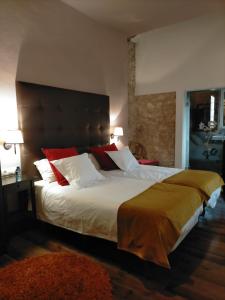een slaapkamer met een groot bed met rode en witte kussens bij Casa Rural el Castillico in Yecla