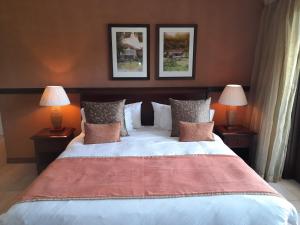 a bedroom with a large bed with two lamps at Eden Island Luxury Accommodation in Eden Island