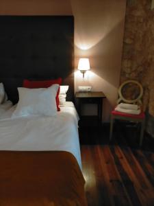 een slaapkamer met een bed en een tafel met een lamp bij Casa Rural el Castillico in Yecla