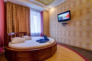 a bedroom with a bed with a tv on a wall at Bansay in Dnipro