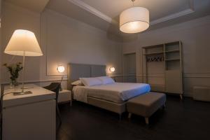 um quarto com uma cama, uma mesa e um candeeiro em Isola Polvese Resort em Castiglione del Lago