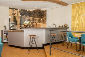 een keuken met blauwe barkrukken en een schilderij aan de muur bij Hotel Am Dom 