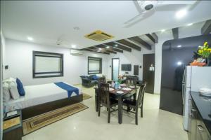 a hotel room with a bed and a dining room at HILL VIEW (VOILA TRANQUIL'N) BEGUMPET in Hyderabad