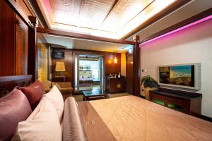 台北的住宿－印石時尚旅館，客房设有床、沙发和电视。