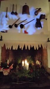 a clock hanging over a fireplace with candles at Casa Rural El Olivar de las Pepinas in Yecla