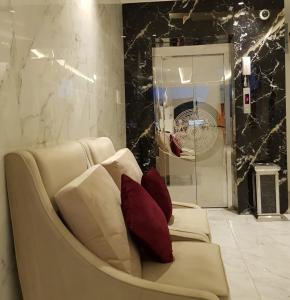 a white couch with red pillows in a room at شقق بيات العالية وادي بن هشبل Bayat Al aliah Apartments in Wadi bin Hashbal in Bin Hashbal