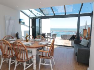 Un comedor con mesa y sillas con vista al mar. en Blue Buoy Cottage, en Brixham