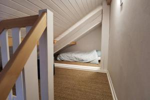 a bed in a small room under the stairs at Ravissant appart proche suisse et pistes de ski familiales in Les Fourgs