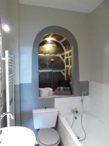a bathroom with a white toilet and a sink at L'Oustal du Sentier in Mur-de-Barrez