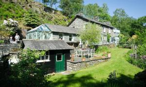 a house with a green door in a yard at The Stable At Oakbank in Elterwater