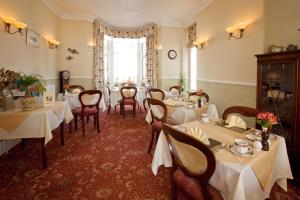 a restaurant with white tables and chairs and a window at The Edwardene in Keswick